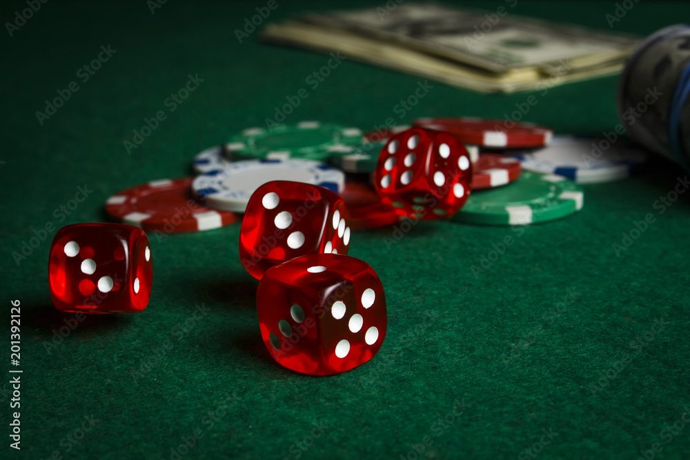 Dice on the poker table against the background of poker chips and dollars Dice on the poker table against the background of poker chips and dollars