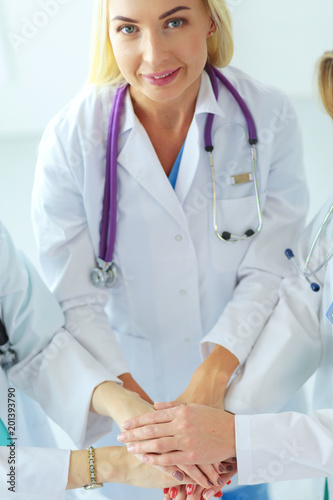 Doctors and nurses in a medical team stacking hands.