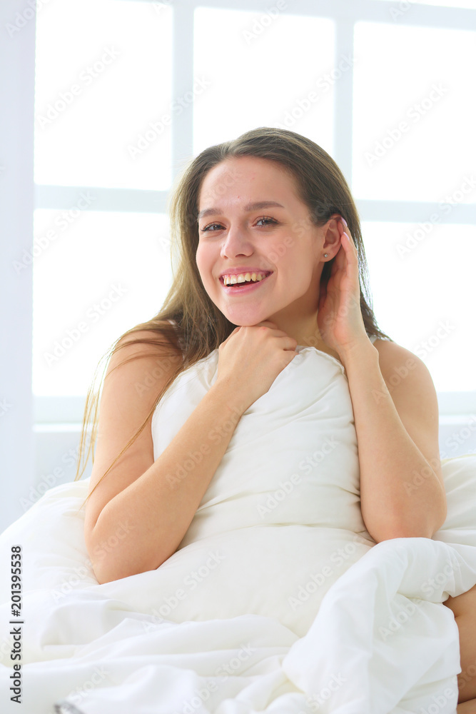 Young caucasian woman covering her head and ears with pillows Young caucasian woman covering her head and ears with pillows