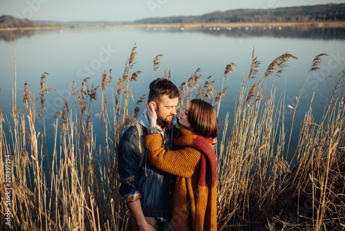 young loving couple on the lake near the reeds photo