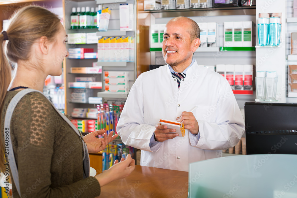 Pharmacist serving client in pharmacy .
