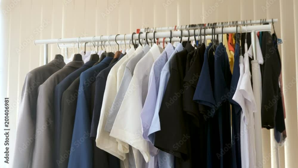 Hanger full of business suits, shirts and t shirts in a shop Hanger full of business suits, shirts and t shirts in a shop