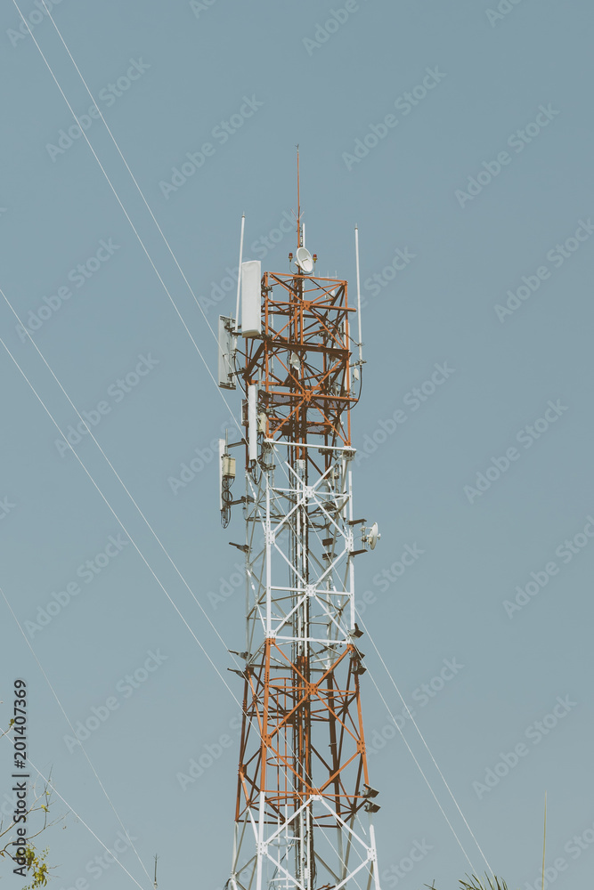 Cell phone tower rises against a blue sky, Used to transmit telephony signal. Cell phone tower rises against a blue sky, Used to transmit telephony signal.