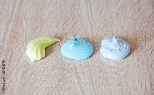 whipped egg white sweets. meringue top view background. sea shell dessert. trendy french cookies flat lay. green and blue color candy. marine mood with tasty meringues. summer vacation on beach.