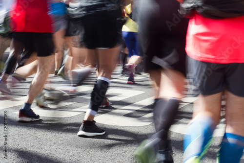 closeup rear view on marathon runners legs and feet with motion blur