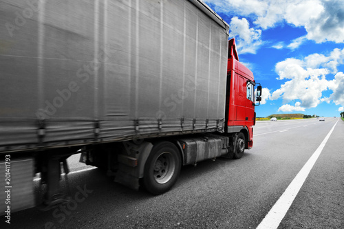 Truck with the trailer on the countryside road against sky