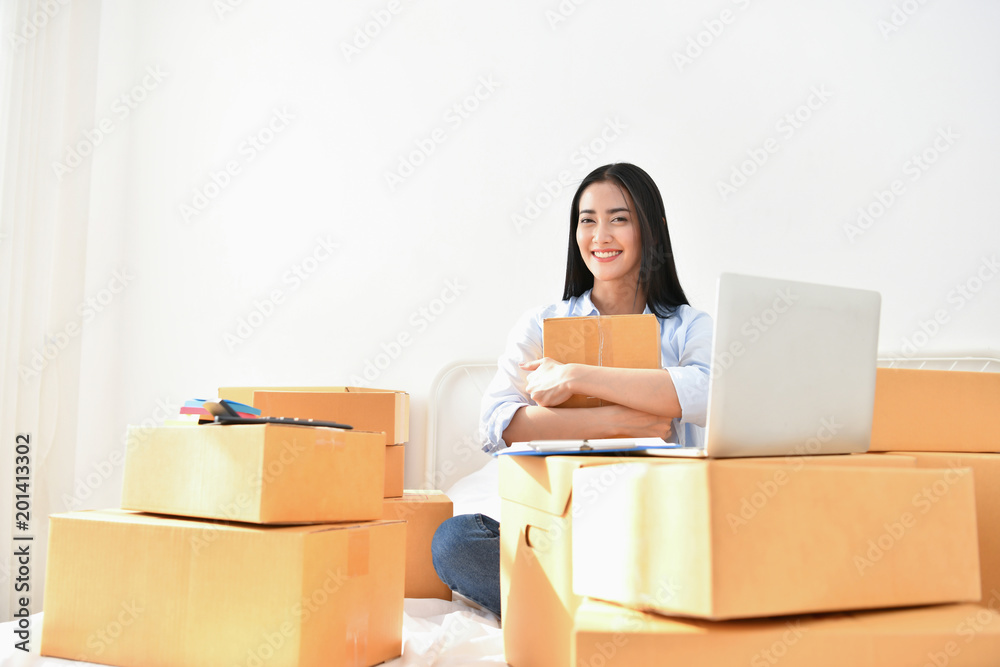 Sme business concept. Young people are packing their packages.Delivery business Small and Medium Enterprise (SMEs). Young woman is working in the house.Young Owner Start up for Business Online. Sme business concept. Young people are packing their packages.Delivery business Small and Medium Enterprise (SMEs). Young woman is working in the house.Young Owner Start up for Business Online.