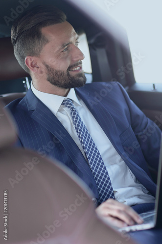 Portrait of a business man in the back seat of a car