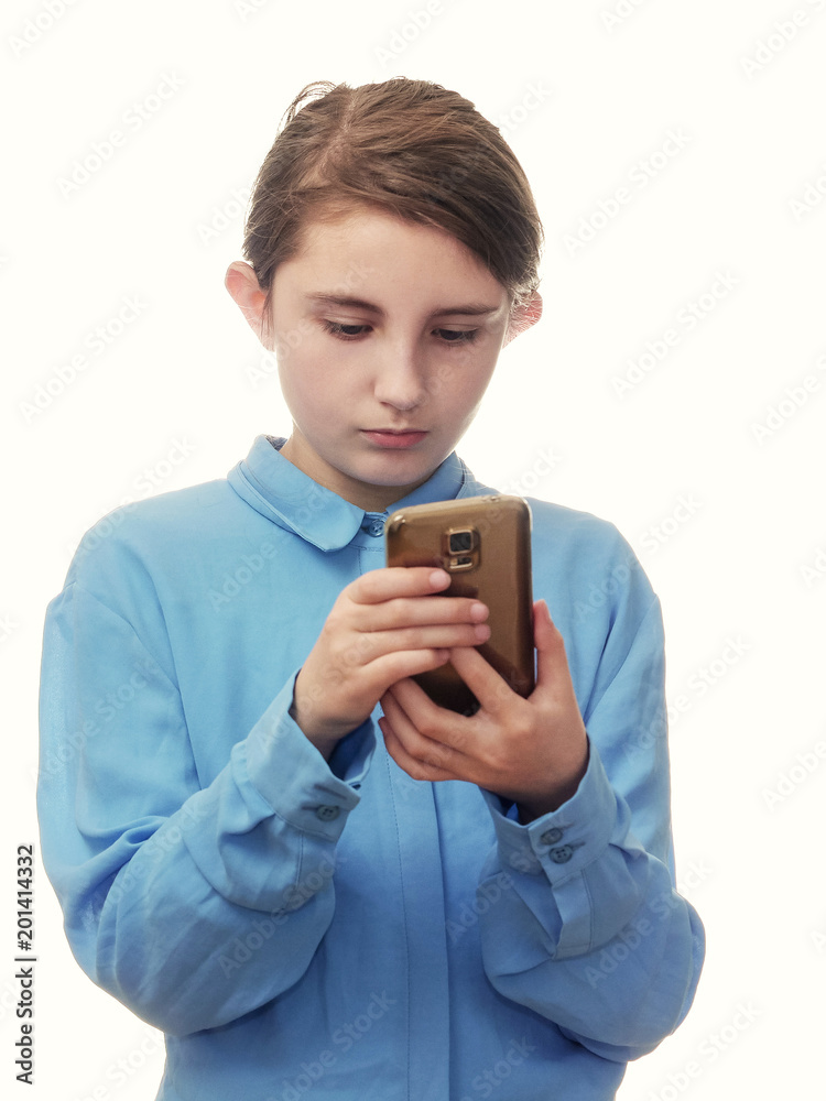 Girl looking at her smartphone, blue shirt, white background.