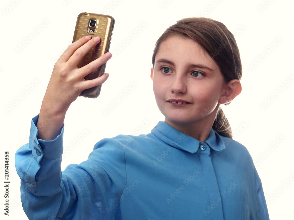 Girl in blue shirt taking selfie, on white background. Smiling expression on her face. Girl in blue shirt taking selfie, on white background. Smiling expression on her face.