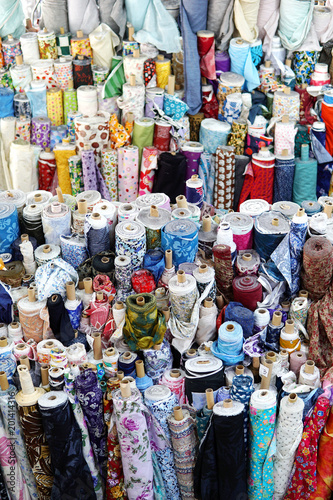 Rolls of fabric and textiles in a factory shop. Multi different colors and patterns on the market.