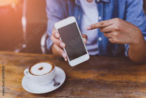 hand woman using smartphone in coffee shop and soft light with vintage filter.