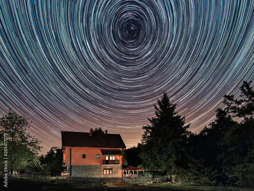 Star trails above the house. Residential building and the star trails ...