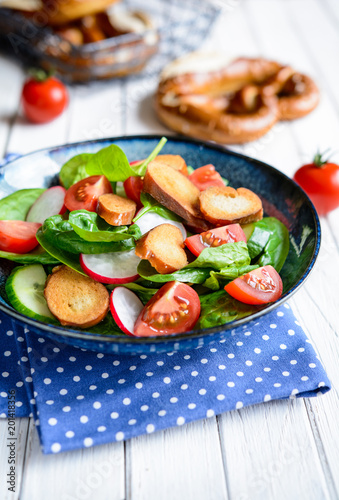 Brezensalat - traditional German pretzel salad with spinach, tomatoes, radish and cucumber