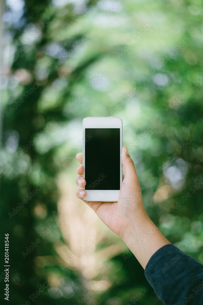 Woman using cellphone in public park.