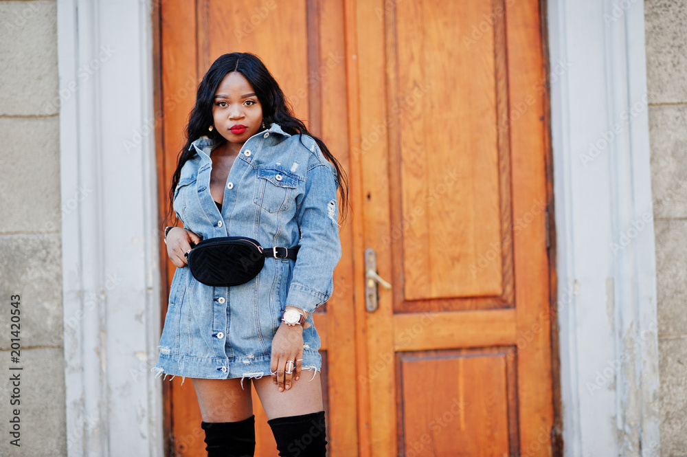 African american girl in jeans dress posed on streets of city. Black stylish model shoot. Stock Photo Adobe Stock