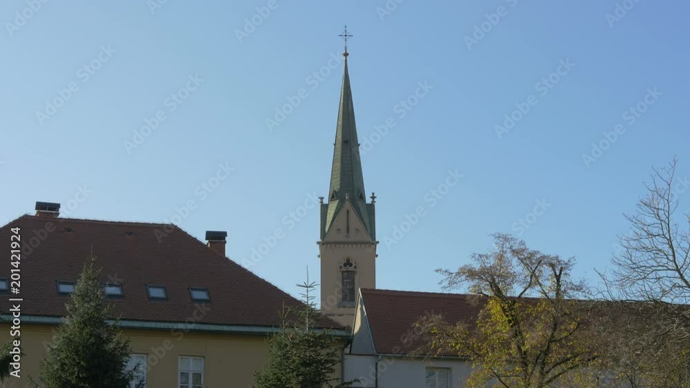 A church tower behind buildings A church tower behind buildings