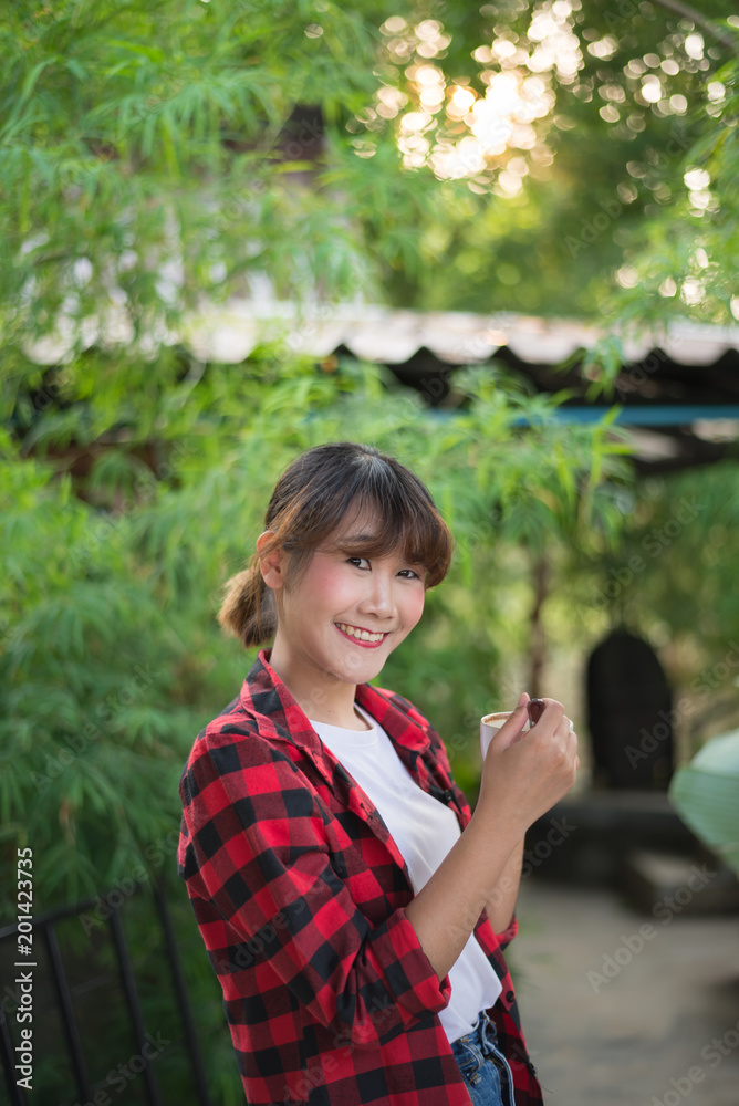 asian beautiful woman drinking hot coffee or tea in the green garden asian beautiful woman drinking hot coffee or tea in the green garden