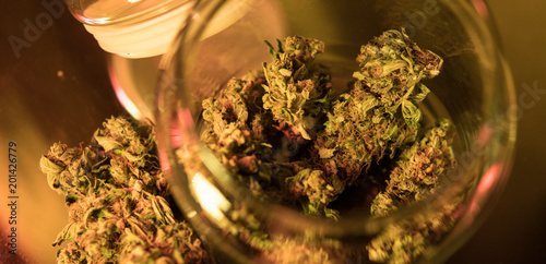 Dope strain of marijuana in a glass jar close-up. Weed buds for smoking photo