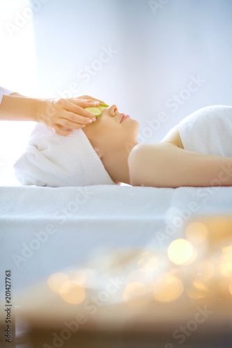 Young woman lying on a massage table,relaxing with eyes closed. Woman. Spa salon