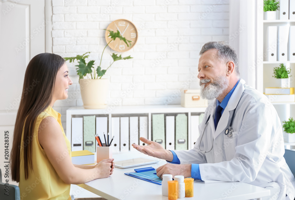 Fototapeta premium Mature doctor consulting patient in clinic