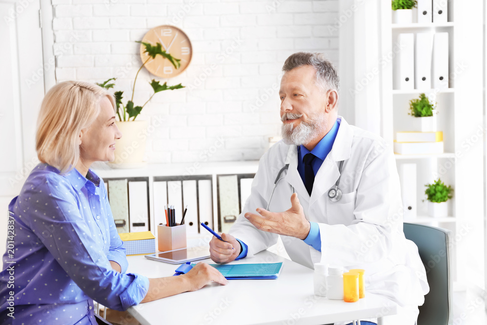 Mature doctor consulting patient in clinic Mature doctor consulting patient in clinic