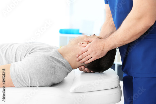 Physiotherapist working with young male patient in clinic