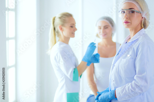 Beautiful woman face near doctor with syringe.