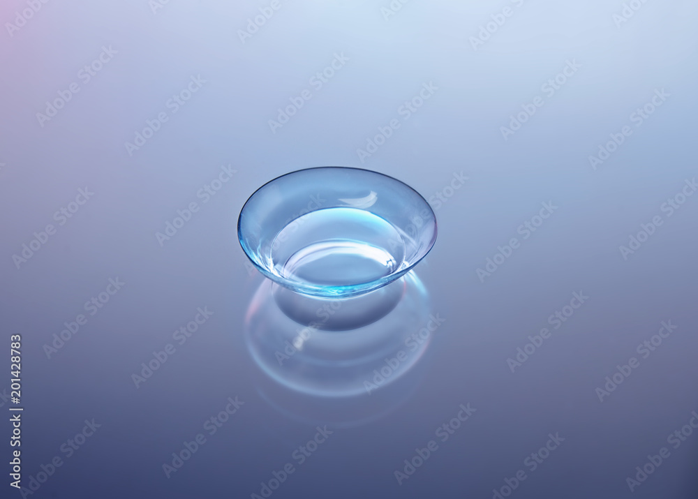 Contact lens on color glass background Contact lens on color glass background
