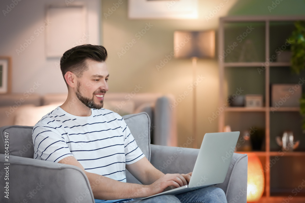 Fototapeta premium Young man using laptop at home