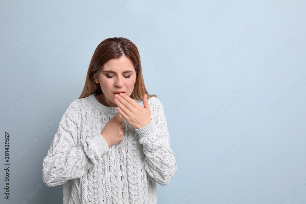 Woman coughing on color background