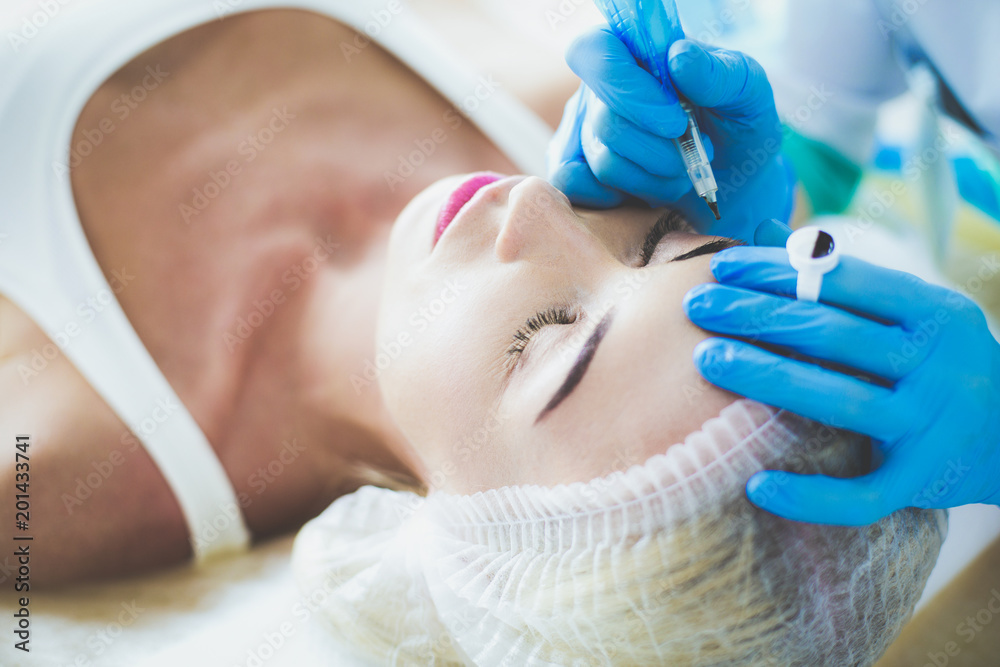 Permanent makeup for eyebrows. Closeup of beautiful woman with thick brows in beauty salon. Permanent makeup for eyebrows. Closeup of beautiful woman with thick brows in beauty salon.