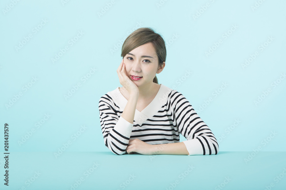 デスクで頬杖をつく若い女性 デスクで頬杖をつく若い女性
