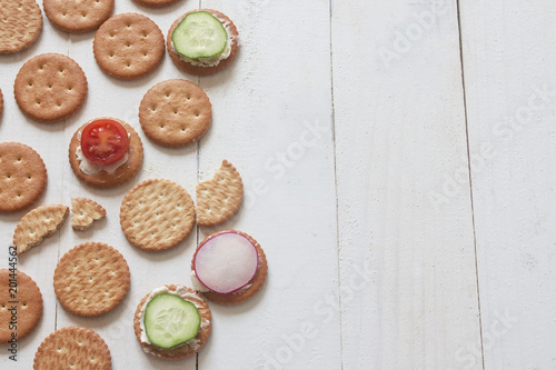 scattered dry crunchy salted cracker with small sandwiches