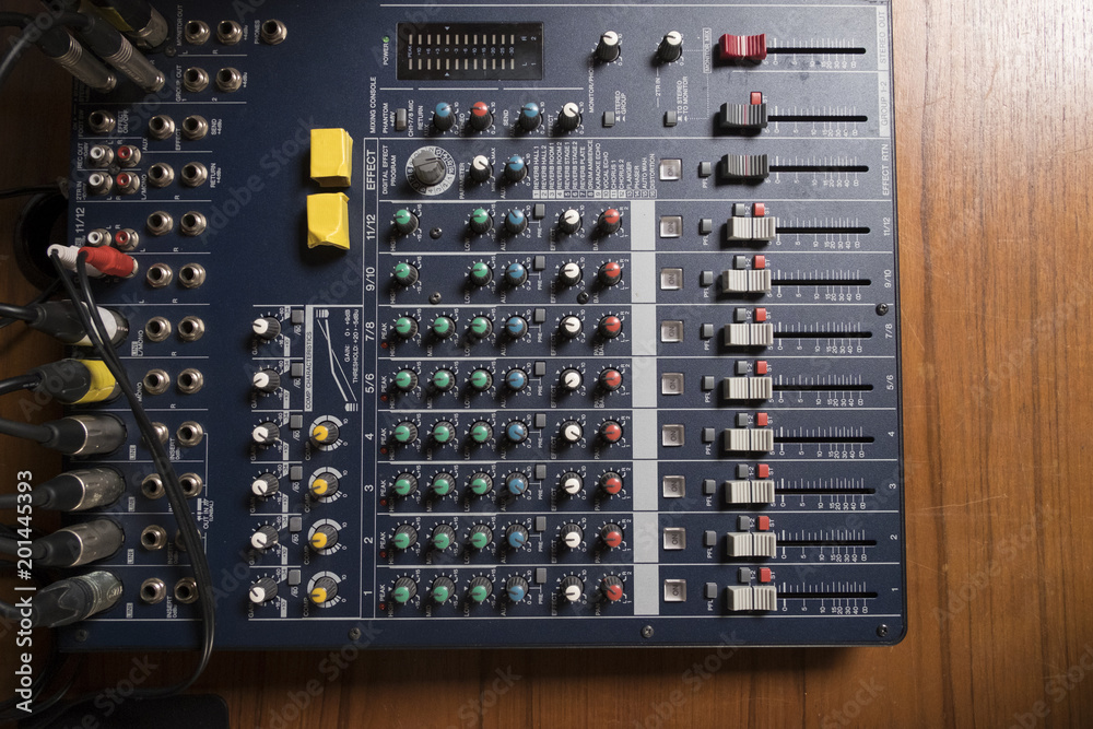 Top view of professional sound mixer controller on wooden table.