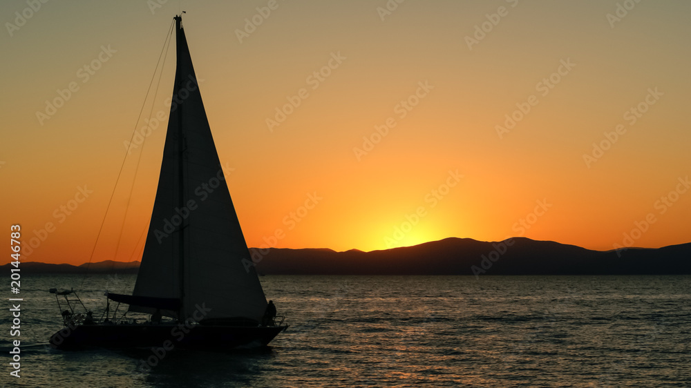 Silhouette of sailing yacht in open sea on beautiful sunset backgroung