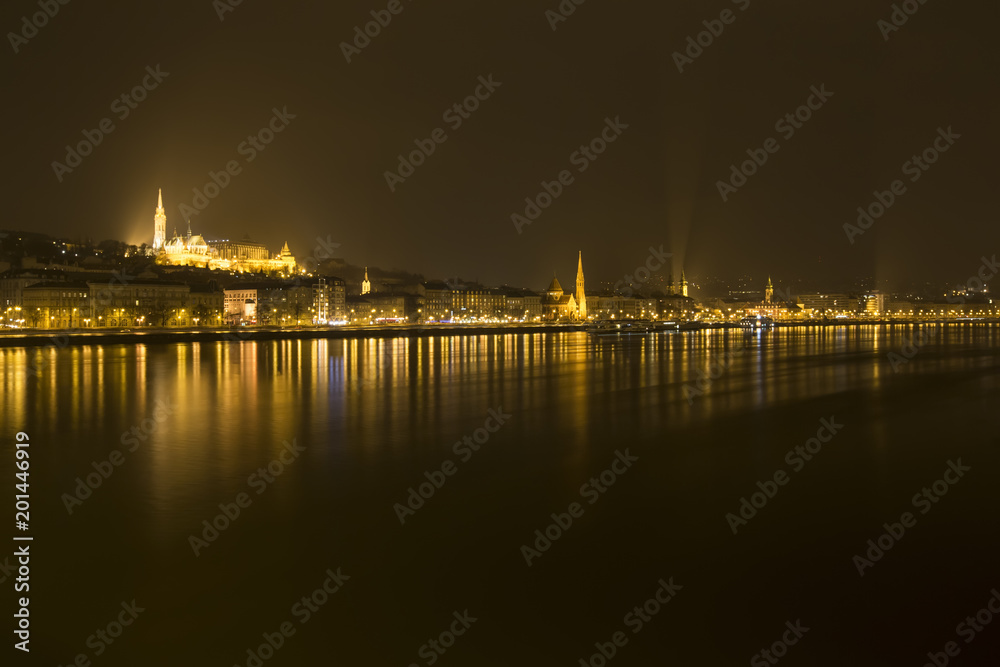 Panoramic view of Budapest by night on Danube river.