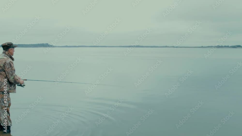 A fisherman with a cigarette The fisherman in boots went into the water and threw the spinning far into the river A fisherman with a cigarette The fisherman in boots went into the water and threw the spinning far into the river