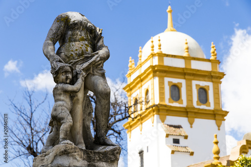 Seville, Spain. Views of a headless statue in the Jardines de las Delicias public gardens, with the tower of the Pabellon de Argentina (Argentine Pavilion) of the Ibero-American Exposition of 1929