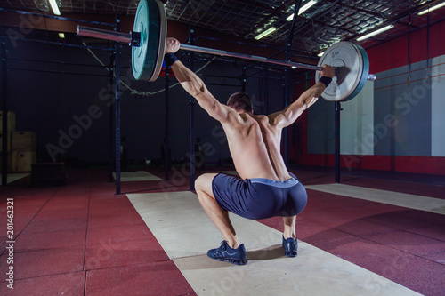 sporty man performing overhead squats with a heavy barbell at the gym complex crossfit overhead performance athlete active lifestyle weightlifting bodybuilder. Crossfit style, deadlift