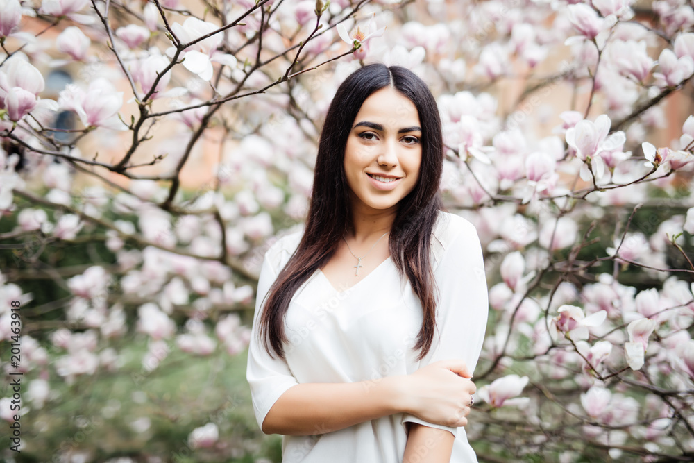 Young beautiful young woman near the blossoming spring tree Young beautiful young woman near the blossoming spring tree