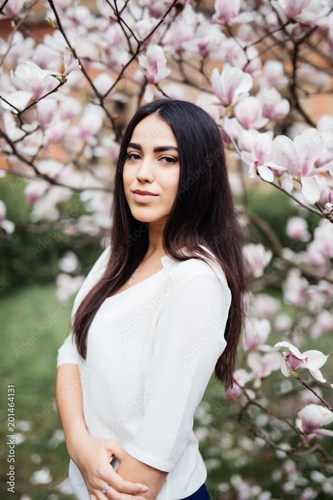 Young beautiful young woman near the blossoming spring tree Young beautiful young woman near the blossoming spring tree