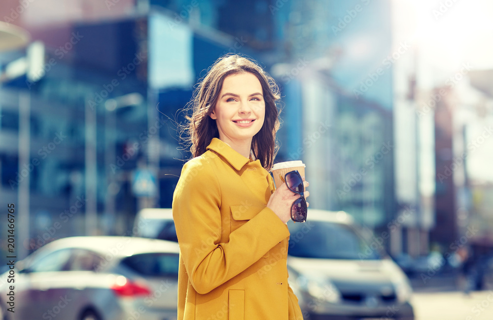 drinks and people concept - happy young woman or teenage girl drinking coffee from paper cup on city street drinks and people concept - happy young woman or teenage girl drinking coffee from paper cup on city street