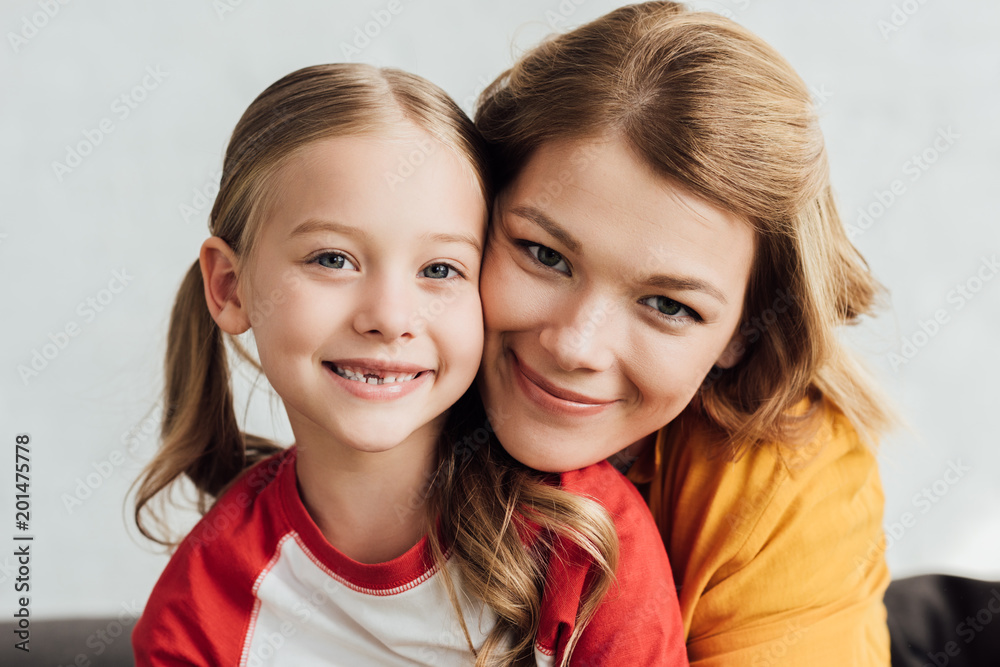 portrait of beautiful happy mother and daughter smiling at camera portrait of beautiful happy mother and daughter smiling at camera