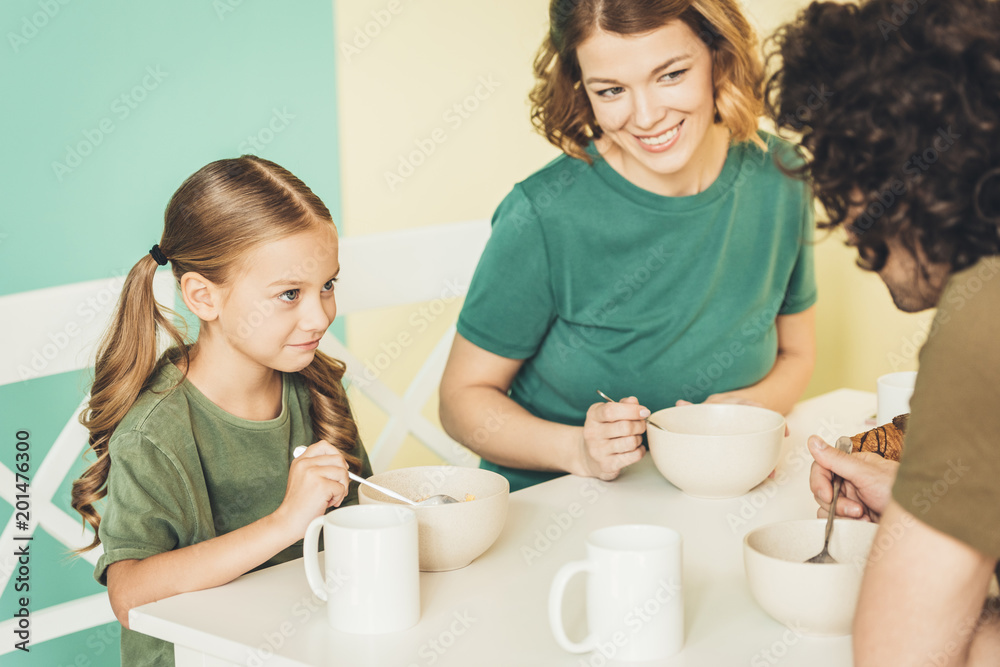 cropped shot of happy young family having breakfast together