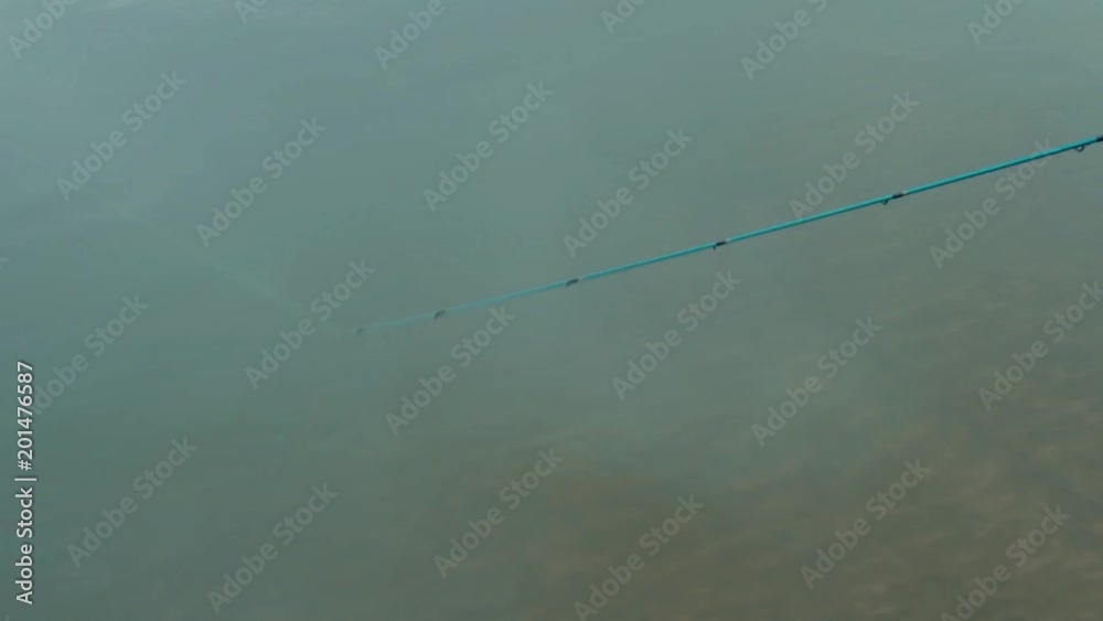 Thin Spinning End Close-up of the thin end of the spinning on the background of water Thin Spinning End Close-up of the thin end of the spinning on the background of water