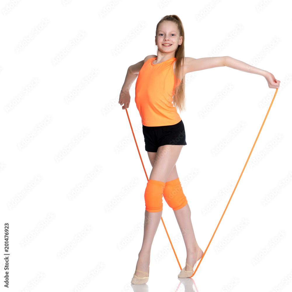 A girl gymnast performs exercises with a skipping rope. A girl gymnast performs exercises with a skipping rope.