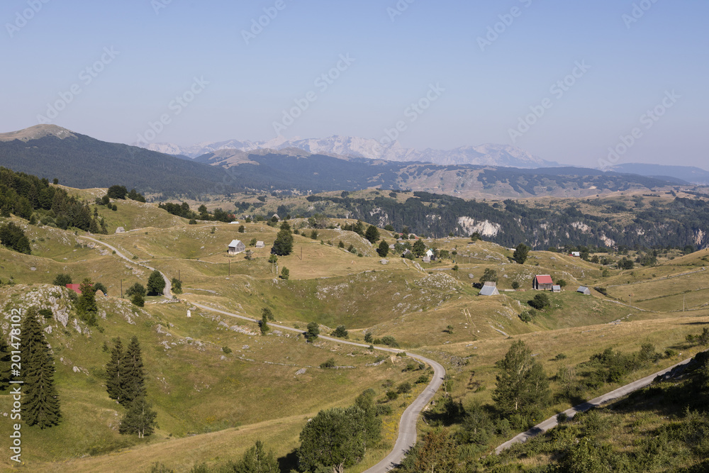 Hilly landscape with houses and a street in Durmitor National Park in Dinaric Alps, Montenegro