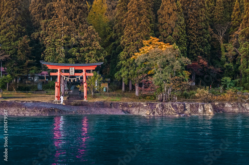 Red Torii of Gozanoishi Shrine at Lake Tazawa ko, Senboku, Akita, Japan. Japanese  characters on wooden sign on top of Torii gate is name of Shrine photo