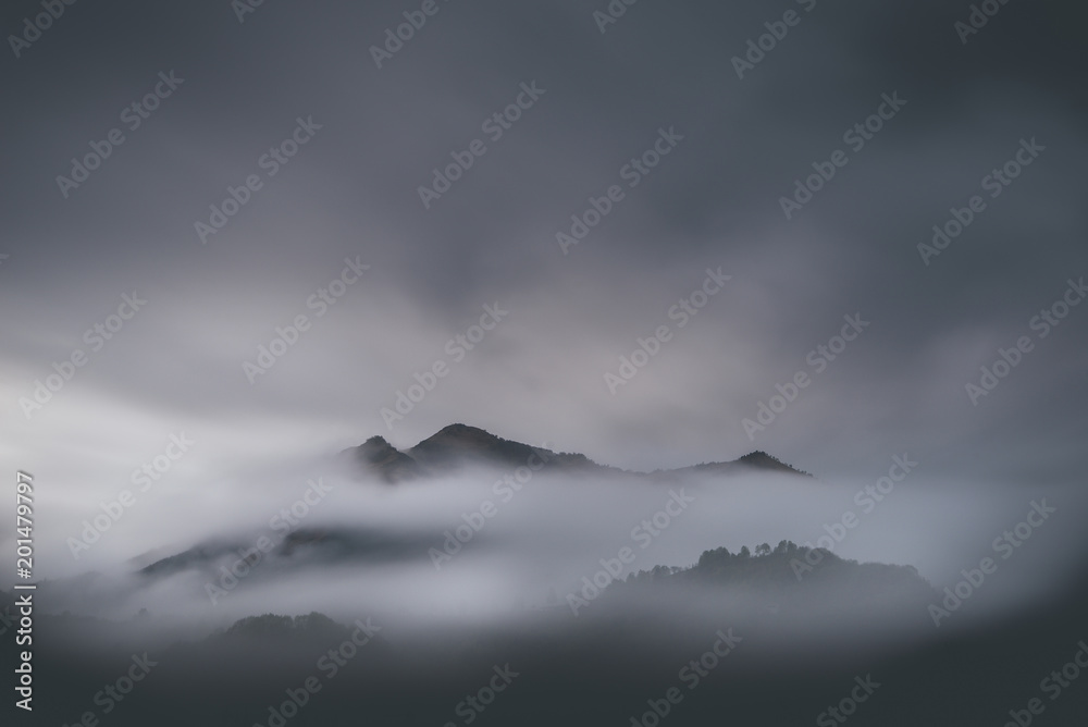 mountain landscape with low clouds - winter mood - desaturated style image